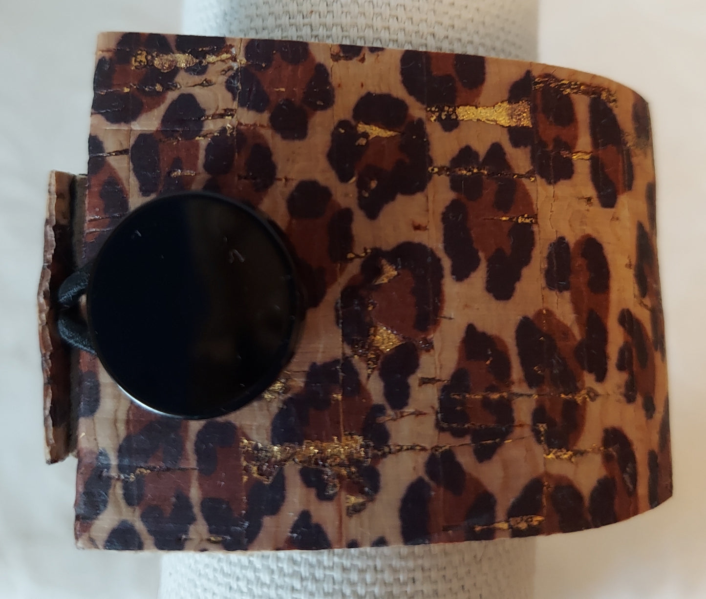 Leopard-themed cork bracelet featuring bold leopard print on natural cork material with a black button clasp for a stylish, eco-friendly accessory.